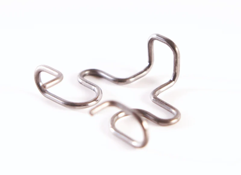 Pieza metálica de alambre conformado con varias curvas para aplicaciones industriales.